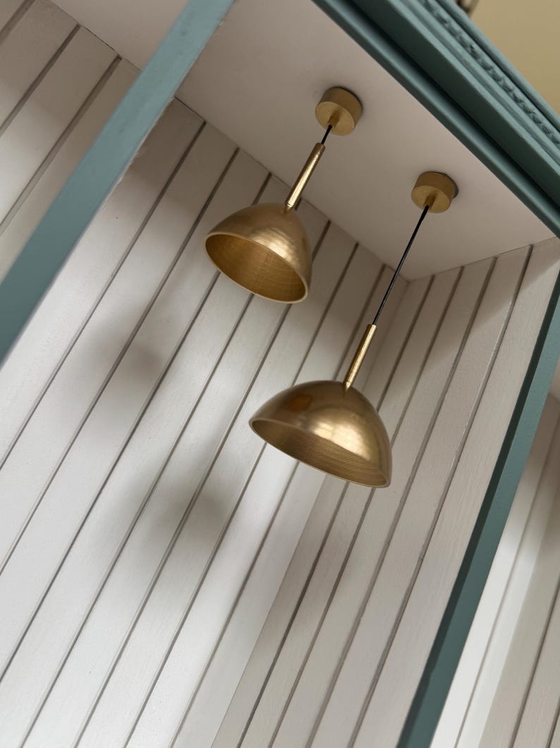 Brass pendant lights in teal dollhouse alcove