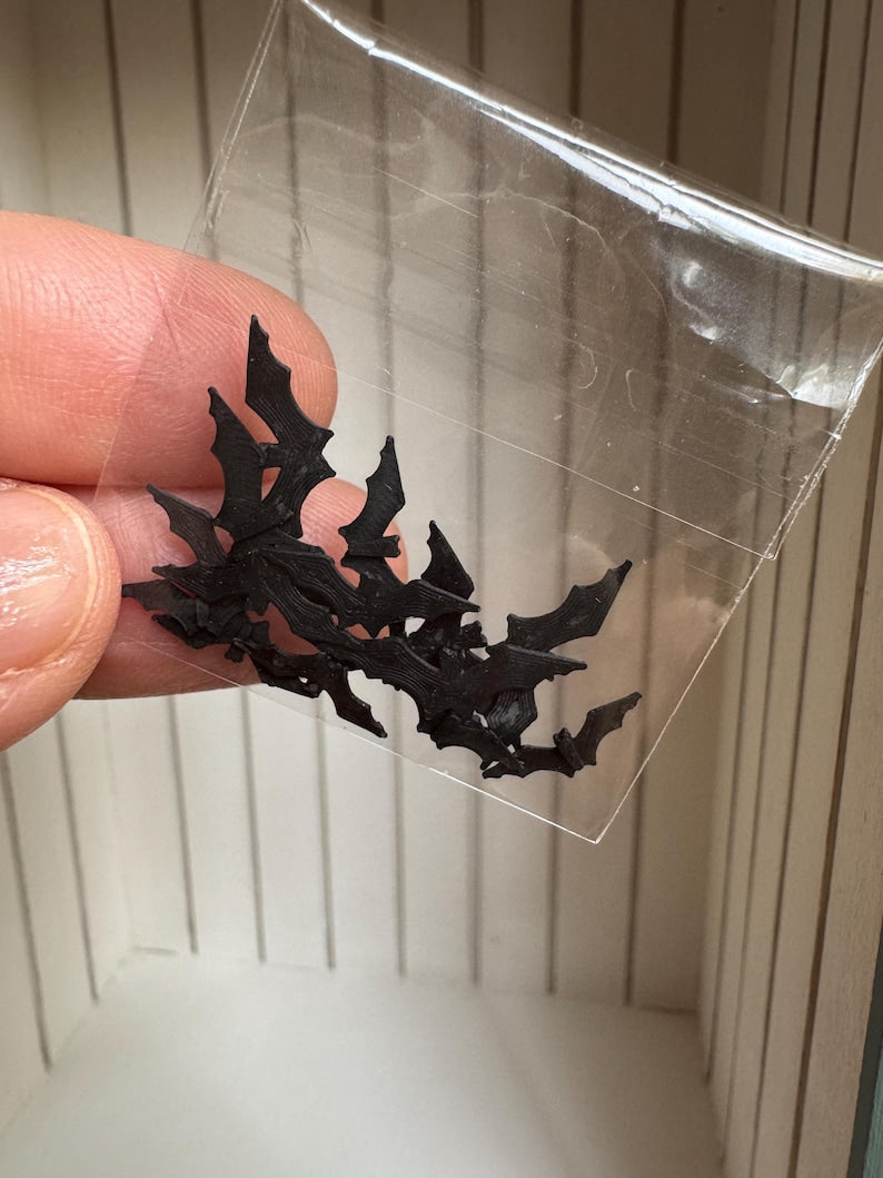 Small black bat decorations in a bag showing three sizes