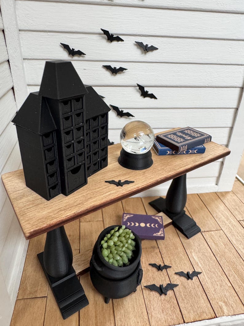 Spooky Halloween dollhouse scene with crystal ball, books, cauldron, and bats