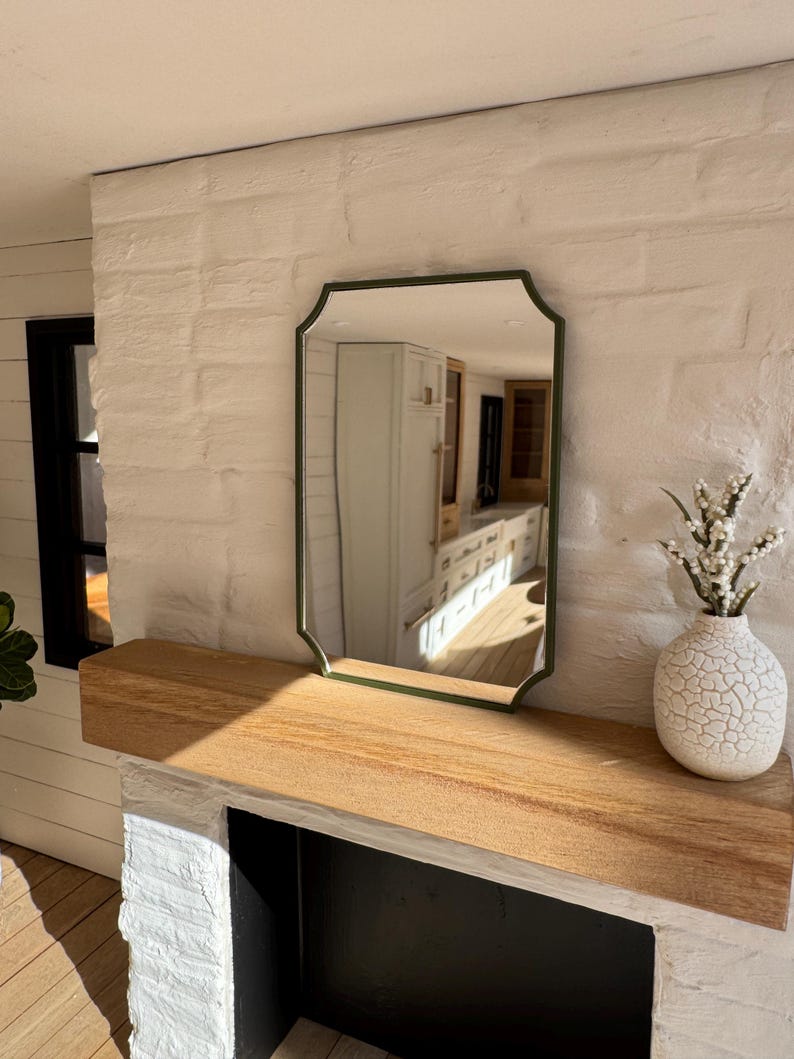 Dark green mirror above dollhouse fireplace mantel